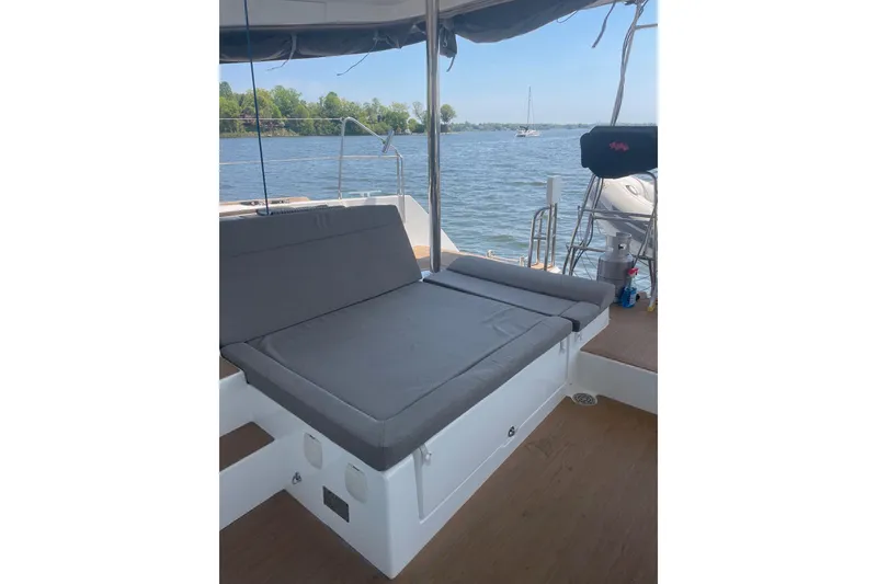 Slide: The Image of 2016 Lagoon 450 F catamaran deck with cushioned seating, overlooking serene waters. - 29