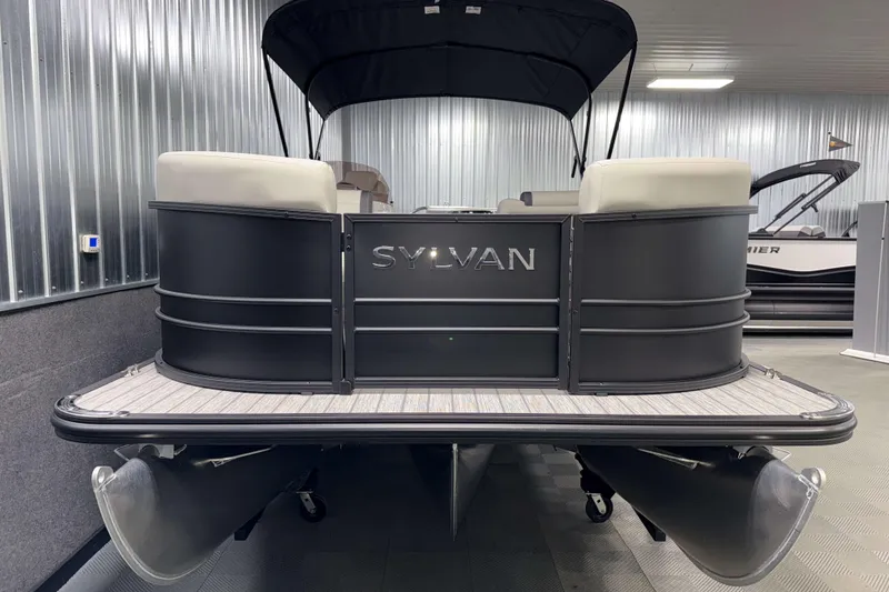 Slide: The Image of 2026 Sylvan Mirage 8520 Cruise PTS Tritoon in showroom, rear view with sleek design. - 18