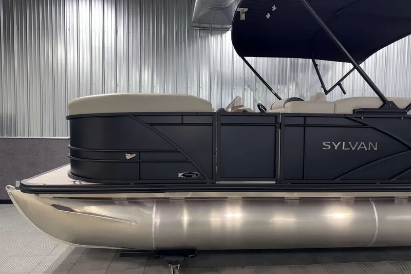 Slide: The Image of 2026 Sylvan Mirage 8520 Cruise PTS Tritoon in showroom, side view with sleek design. - 20