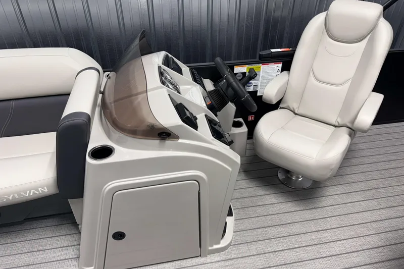 Slide: The Image of 2026 Sylvan Mirage 8520 Cruise PTS Tritoon helm with plush captain's chair and sleek dashboard. - 6
