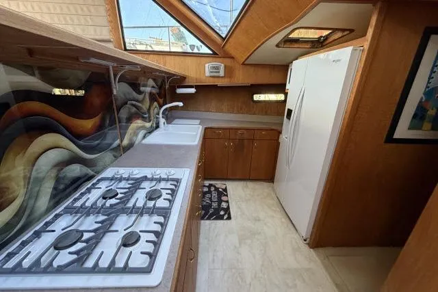 Slide: The Image of Spacious kitchen in 1986 Fexas Custom 57 yacht with modern appliances and artistic backsplash. - 10