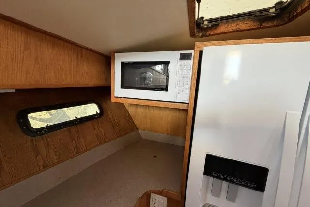 Slide: The Image of Interior of 1986 Fexas Custom 57 boat with microwave and refrigerator. - 13