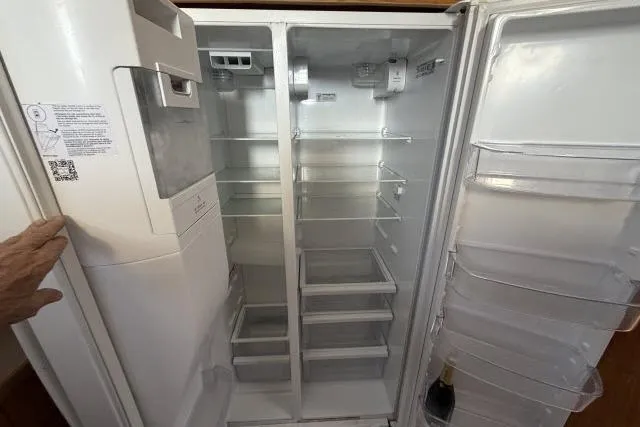 Slide: The Image of Empty refrigerator interior with multiple shelves and compartments, Fexas Custom 57, 1986 model. - 14