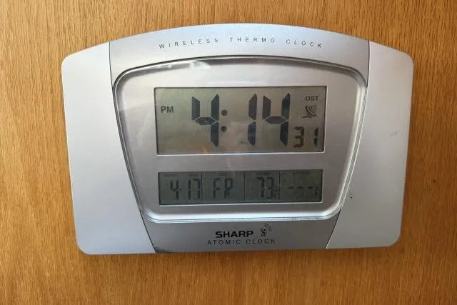 Slide: The Image of Digital atomic clock displaying time, date, and temperature on a wooden surface. - 16