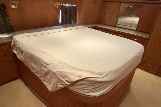 Slide: The Image of Interior of 1986 Fexas Custom 57 yacht with a neatly made bed and wooden cabinetry. - 18