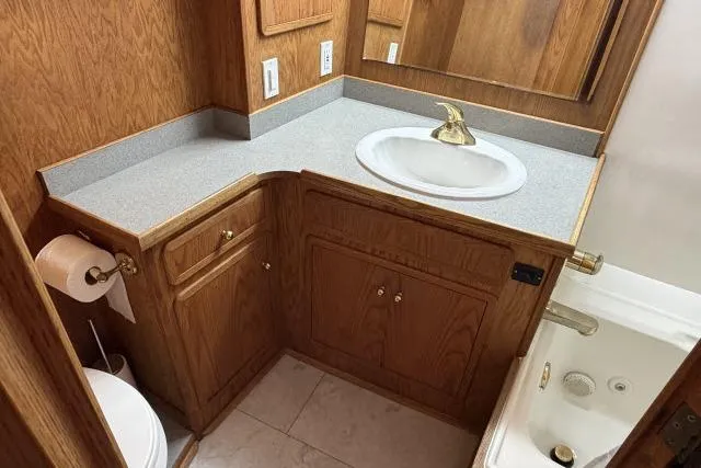 Slide: The Image of 1986 Fexas Custom 57 bathroom with wooden cabinetry, sink, and toilet. - 21