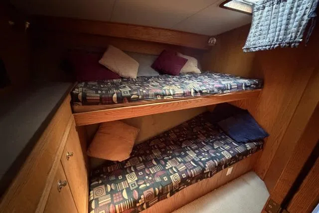 Slide: The Image of Bunk beds in 1986 Fexas Custom 57 yacht cabin with patterned bedding and pillows. - 24