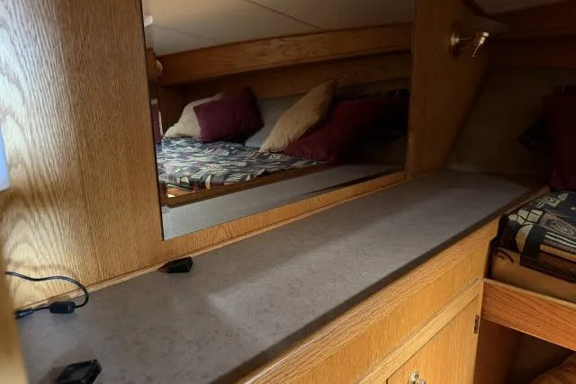 Slide: The Image of 1986 Fexas Custom 57 yacht interior with wooden cabinetry and cozy bedding. - 26