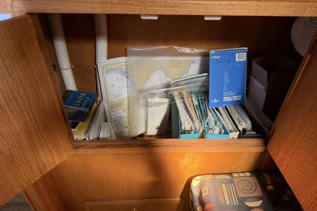 Slide: The Image of Cabinet in 1986 Fexas Custom 57 yacht with maps, books, and a logbook. - 27
