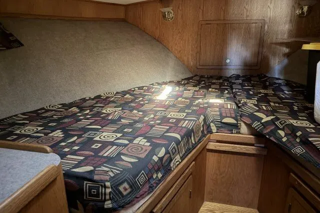 Slide: The Image of 1986 Fexas Custom 57 cabin interior with patterned bedding and wooden cabinetry. - 28