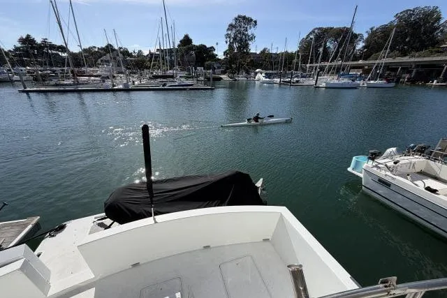 Slide: The Image of 1986 Fexas Custom 57 yacht docked in a marina with kayaker nearby. - 44