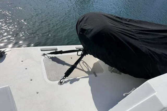 Slide: The Image of 1986 Fexas Custom 57 boat deck with covered equipment, near water. - 46