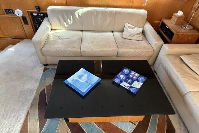 Slide: The Image of Luxurious 1986 Fexas Custom 57 yacht interior with beige sofas and modern black coffee table. - 5