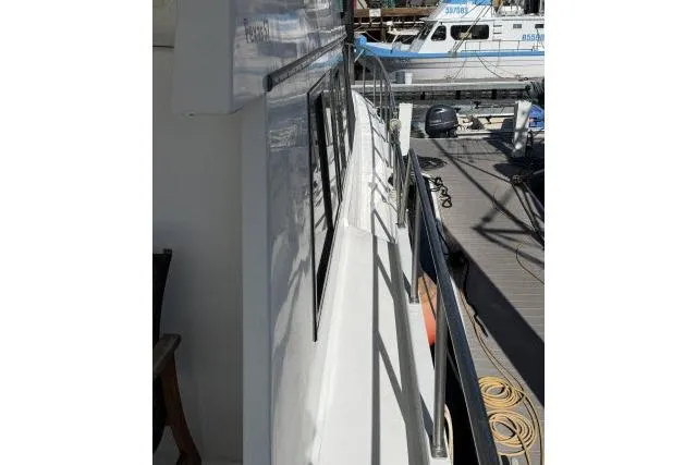 Slide: The Image of 1986 Fexas Custom 57 yacht docked, showcasing sleek side view and marina setting. - 53