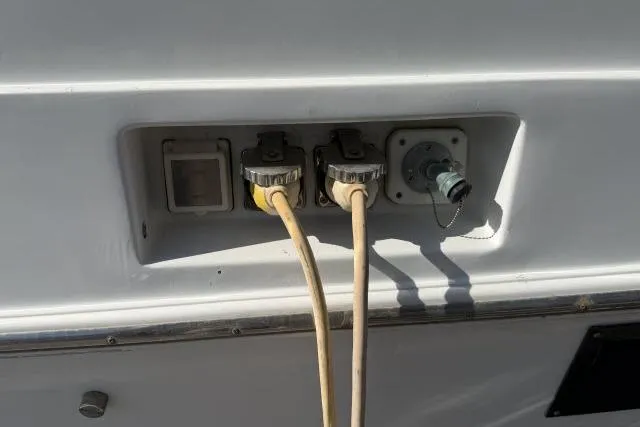 Slide: The Image of Electrical connections on a 1986 Fexas Custom 57 boat, featuring dual power cables. - 58