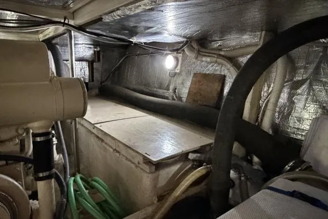 Slide: The Image of Engine room of 1986 Fexas Custom 57 boat with visible machinery and insulation. - 62