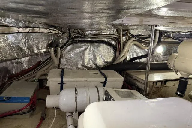 Slide: The Image of Engine room of 1986 Fexas Custom 57 boat with visible wiring and equipment. - 64