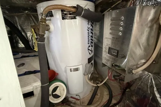 Slide: The Image of Engine room of 1986 Fexas Custom 57 with water heater and electrical panel. - 66