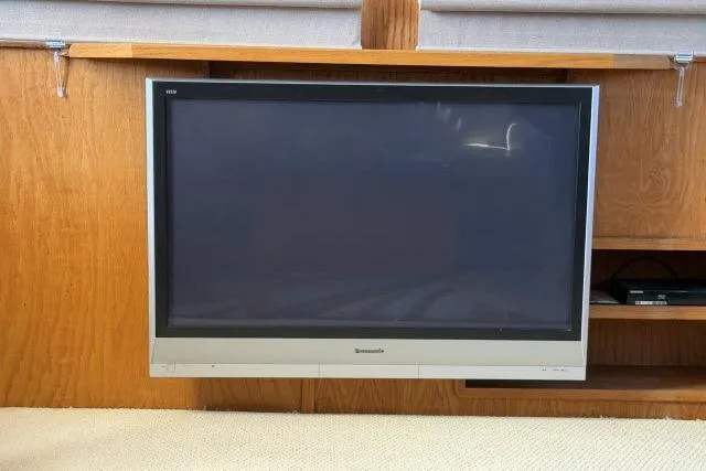 Slide: The Image of Flat-screen TV mounted on wooden panel inside a 1986 Fexas Custom 57 yacht. - 8