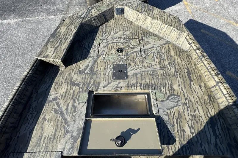 Slide: The Image of 2026 SeaArk 1960 Slayer Pro boat with camouflage design and storage compartment. - 11