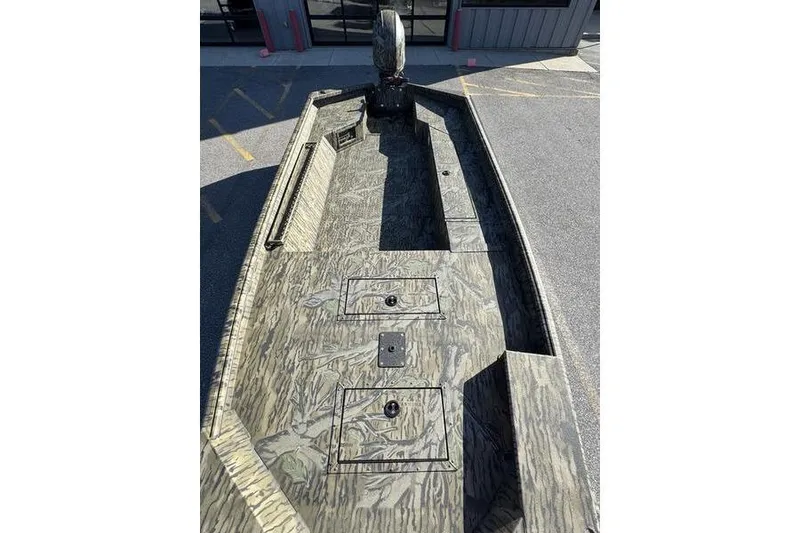 Slide: The Image of 2026 SeaArk 1960 Slayer Pro boat with camouflage design, viewed from above in a parking lot. - 13