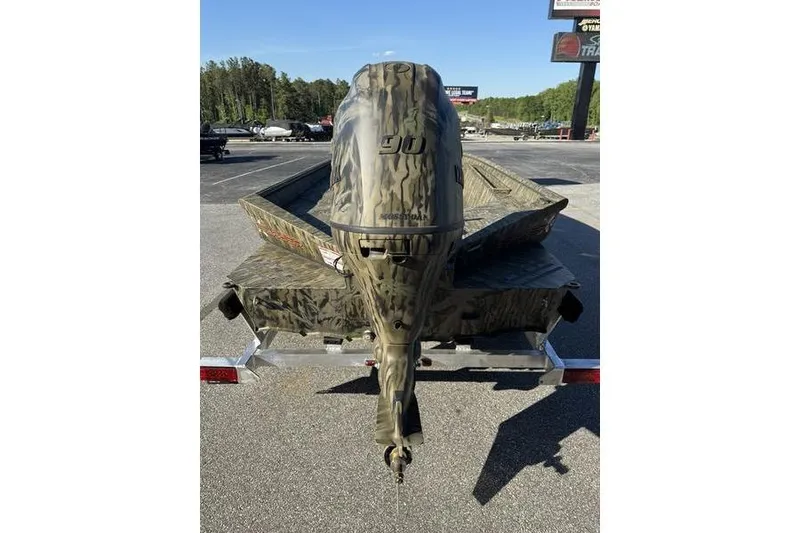 Slide: The Image of 2026 SeaArk 1960 Slayer Pro boat with camouflage design on a trailer. - 3