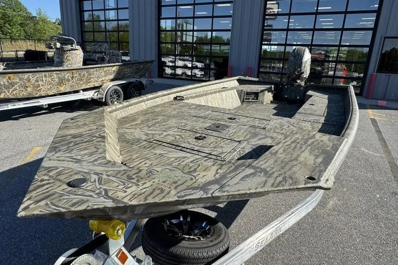 Slide: The Image of 2026 SeaArk 1960 Slayer Pro boat with camouflage design on a trailer. - 6