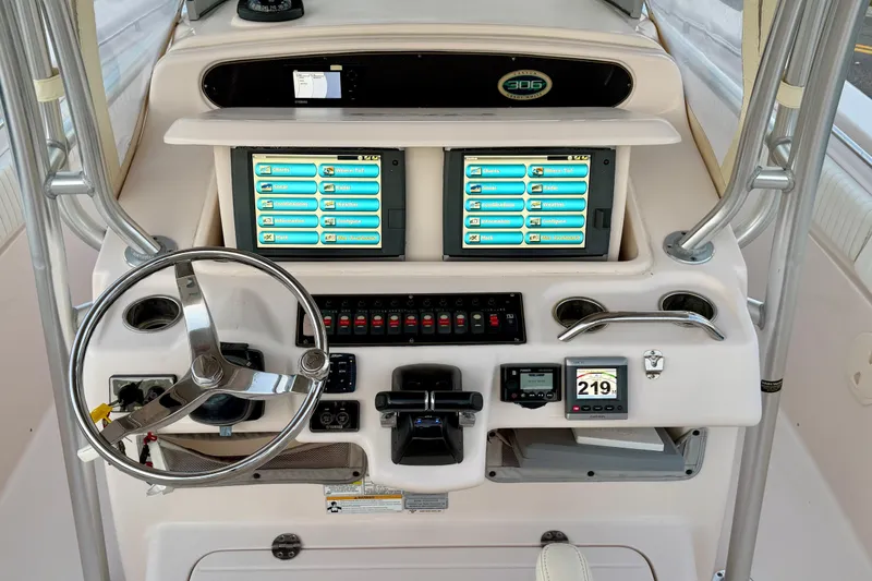 Slide: The Image of 2013 Grady-White Canyon 306 boat dashboard with dual screens and steering wheel. - 10