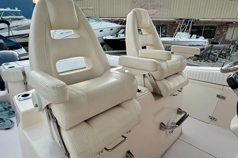 Slide: The Image of Luxury seating on a 2013 Grady-White Canyon 306 boat, featuring plush, adjustable captain chairs. - 11