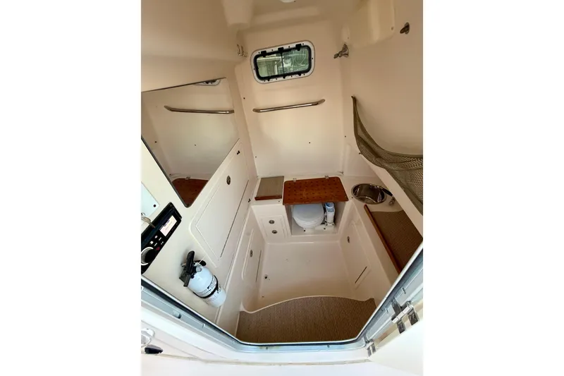 Slide: The Image of 2013 Grady-White Canyon 306 cabin interior with sink, storage, and seating. - 14