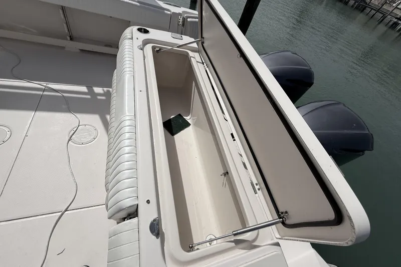 Slide: The Image of Open storage compartment on 2013 Grady-White Canyon 306 boat, docked by water. - 18