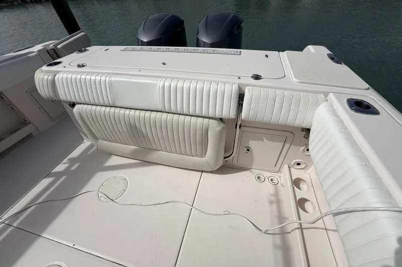 Slide: The Image of 2013 Grady-White Canyon 306 boat interior with white seating and dual engines. - 19