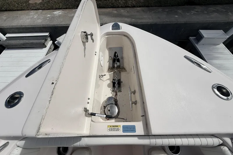 Slide: The Image of 2013 Grady-White Canyon 306 boat anchor compartment, open lid, docked at marina. - 25