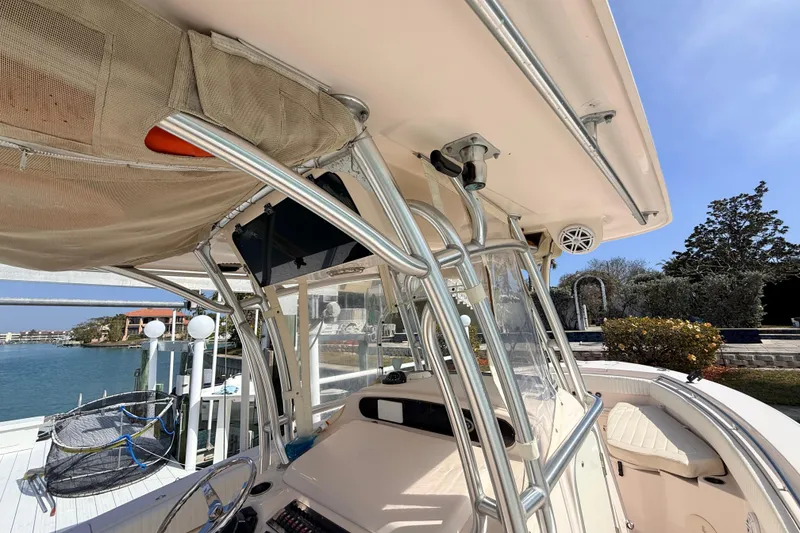 Slide: The Image of 2013 Grady-White Canyon 306 boat interior with helm and seating, docked by waterfront. - 27