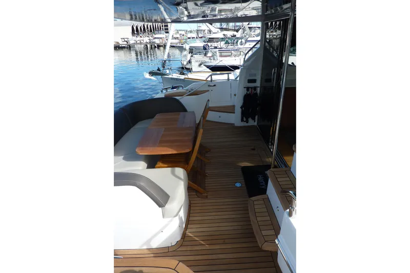 Slide: The Image of 2019 Princess F49 yacht deck with seating and wooden table, docked at marina. - 6