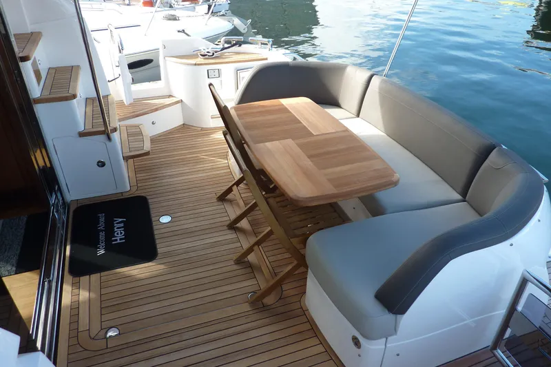 Slide: The Image of Luxurious 2019 Princess F49 yacht deck with seating and wooden table by the water. - 7