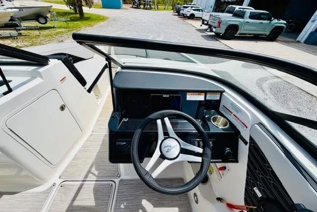 Slide: The Image of 2025 Sea Ray SPX 210 boat dashboard with steering wheel and control panel. - 13