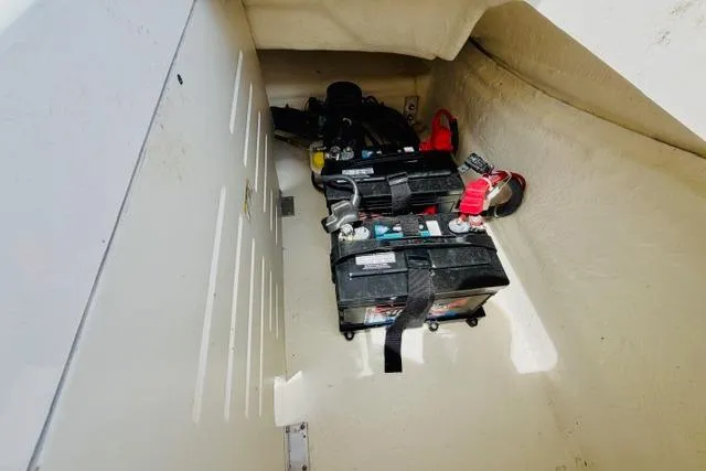 Slide: The Image of Battery compartment of 2025 Sea Ray SPX 210 boat, featuring dual batteries and secure straps. - 19