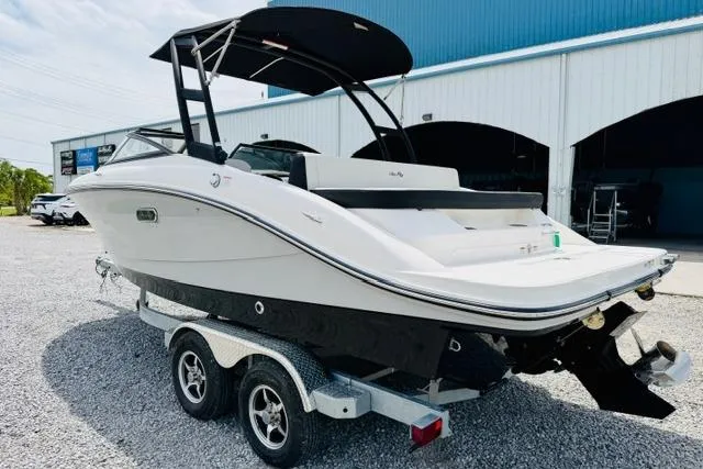 Slide: The Image of 2025 Sea Ray SPX 210 boat on trailer, parked outside a blue building. - 4