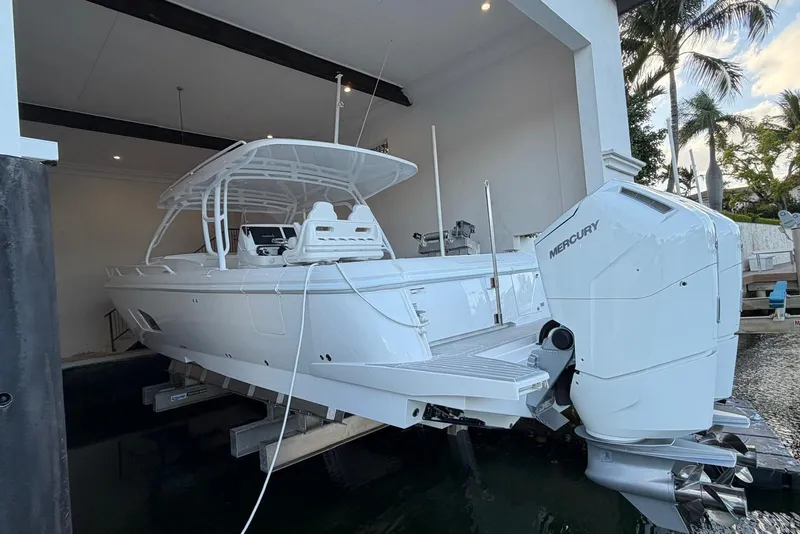 Slide: The Image of 2024 Intrepid 41 Valor boat with Mercury engines in a covered dock setting. - 2