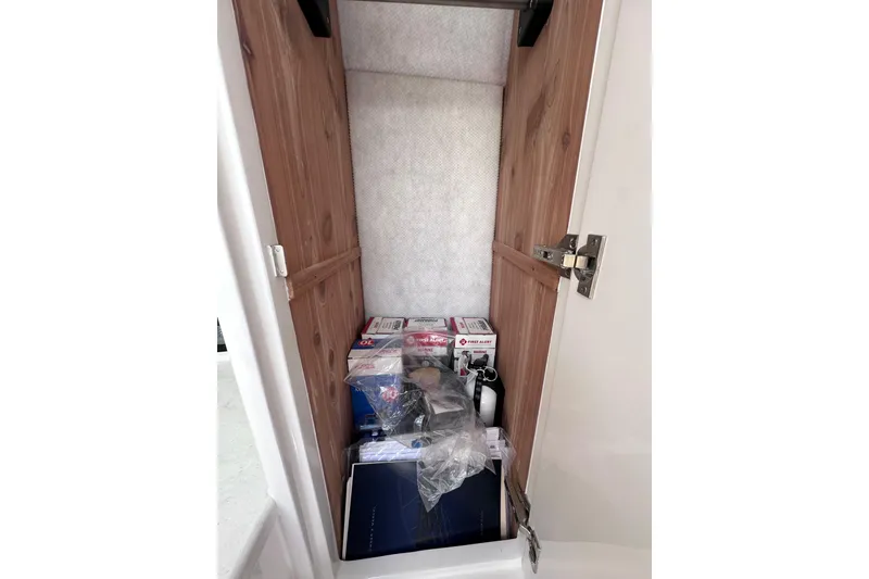 Slide: The Image of Storage compartment on 2024 Intrepid 41 Valor boat, containing safety equipment and supplies. - 50