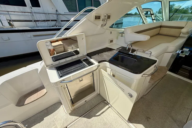 Slide: The Image of Luxurious 2012 Sea Ray 410 Sundancer yacht interior with kitchenette and seating area. - 11