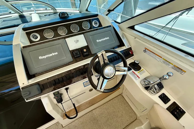 Slide: The Image of Cockpit of 2012 Sea Ray 410 Sundancer with Raymarine navigation system and steering wheel. - 17