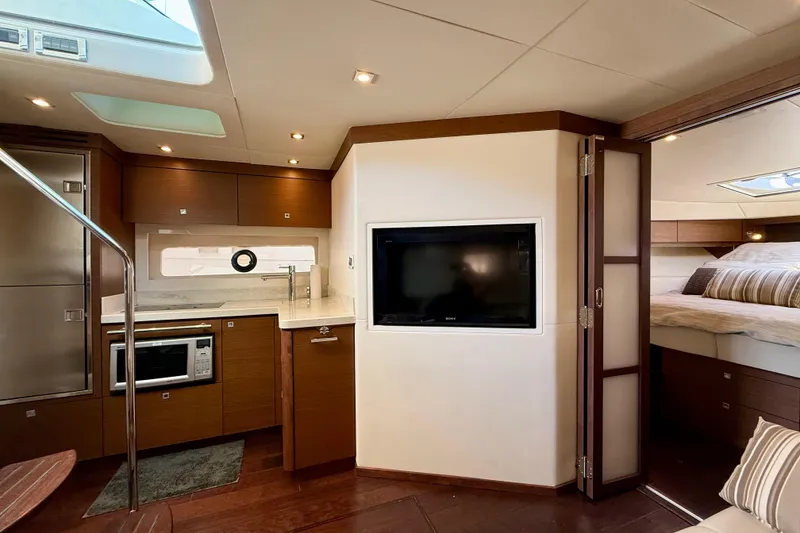 Slide: The Image of Luxurious interior of 2012 Sea Ray 410 Sundancer yacht with modern kitchen and cozy bedroom. - 21