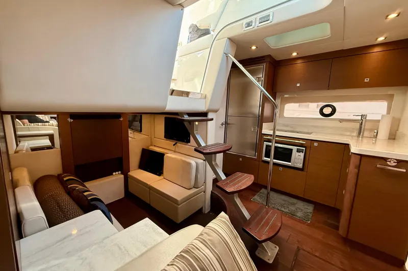 Slide: The Image of Luxurious interior of 2012 Sea Ray 410 Sundancer yacht with modern kitchen and seating area. - 23