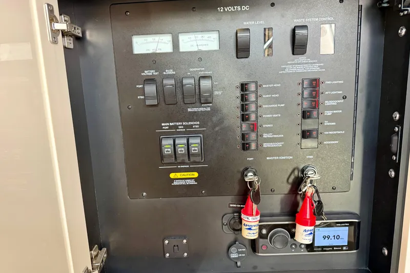 Slide: The Image of Electrical control panel of a 2012 Sea Ray 410 Sundancer boat, featuring switches and gauges. - 54