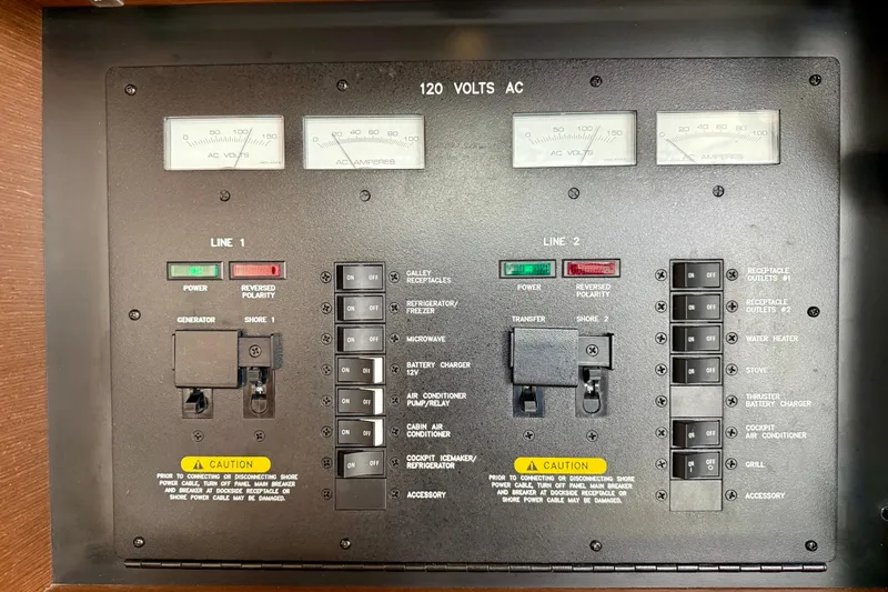 Slide: The Image of Electrical control panel of a 2012 Sea Ray 410 Sundancer boat, showing switches and meters. - 55