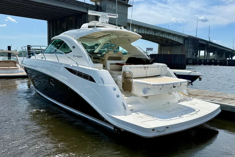 Slide: The Image of 2012 Sea Ray 410 Sundancer yacht docked near a bridge on a sunny day. - 56