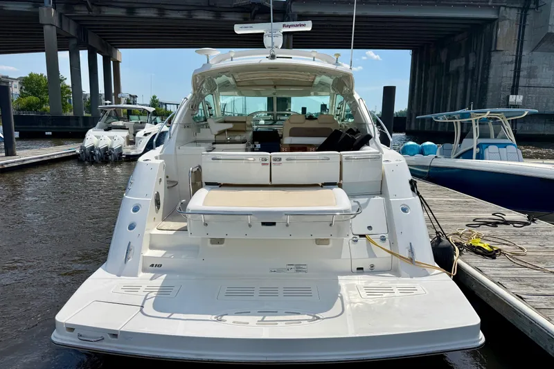 Slide: The Image of 2012 Sea Ray 410 Sundancer yacht docked under a bridge, rear view. - 57