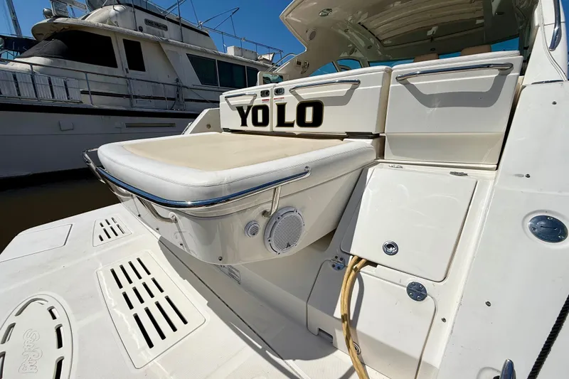 Slide: The Image of 2012 Sea Ray 410 Sundancer yacht with "YOLO" text on the back, docked at marina. - 6